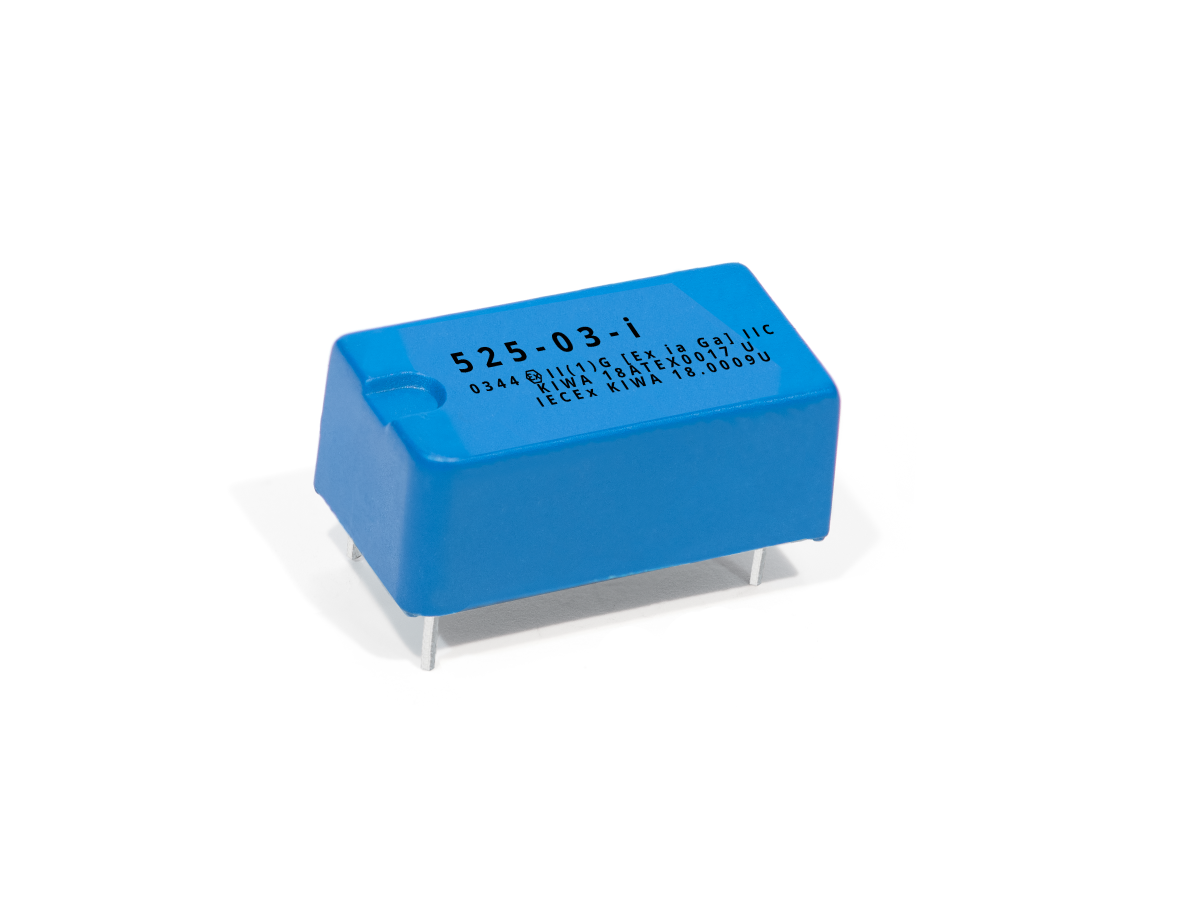 A blue rectangular electronic component, possibly part of the 525 Series Optocouplers, features four metal pins at the bottom and black alphanumeric codes on its top, all displayed against a white background. by Standex Detect