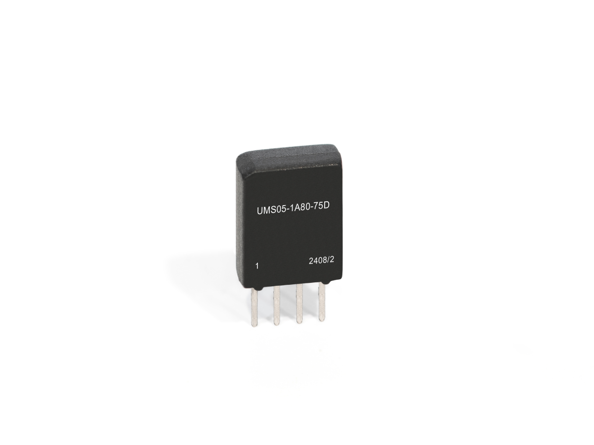 A black Reed Relay from the UMS Series with four metal pins, labeled UMS05-1A80-75D and 2408/2, stands upright on a white background. by Standex Detect