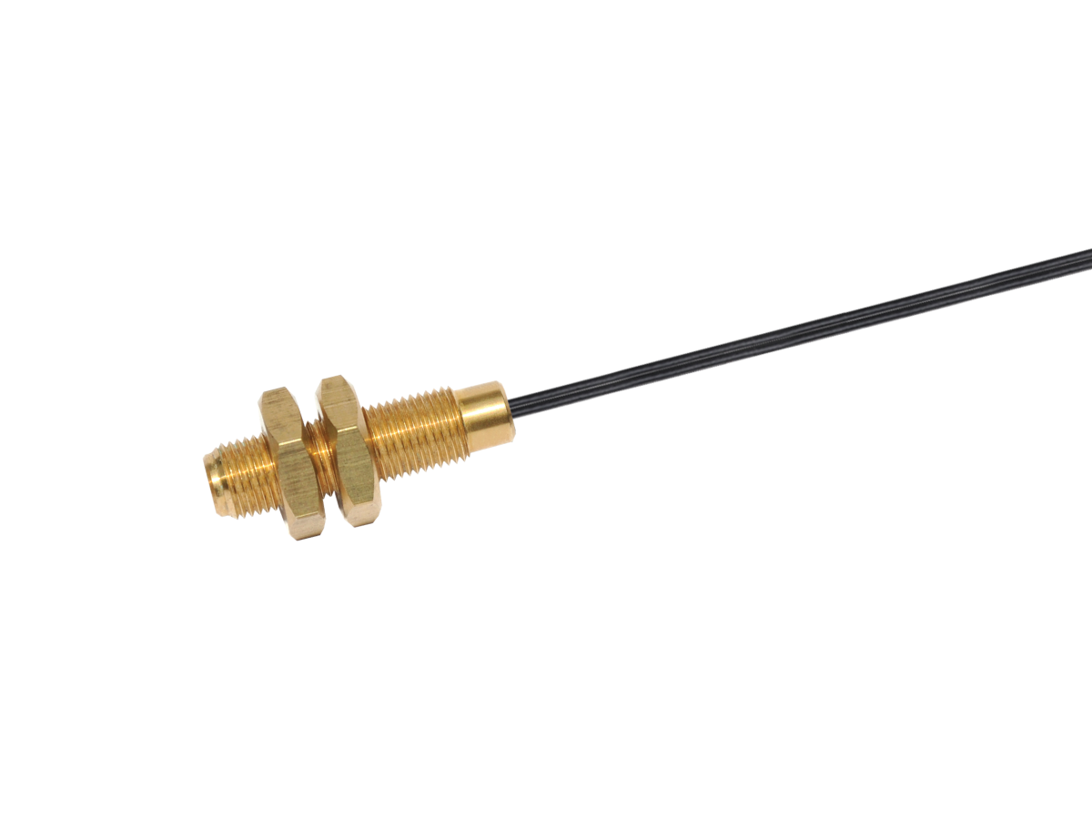 A gold-colored metal SMA connector with two hex nuts, attached to a black coaxial cable, is shown isolated on a white background—ideal for use with MK11 reed sensor applications. by Standex Detect