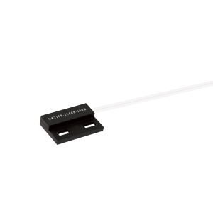 A black rectangular MK21PR Series reed sensor with two elongated mounting holes and attached white wires is shown on a white background. The sensor features white printed text on its surface. by Standex Detect
